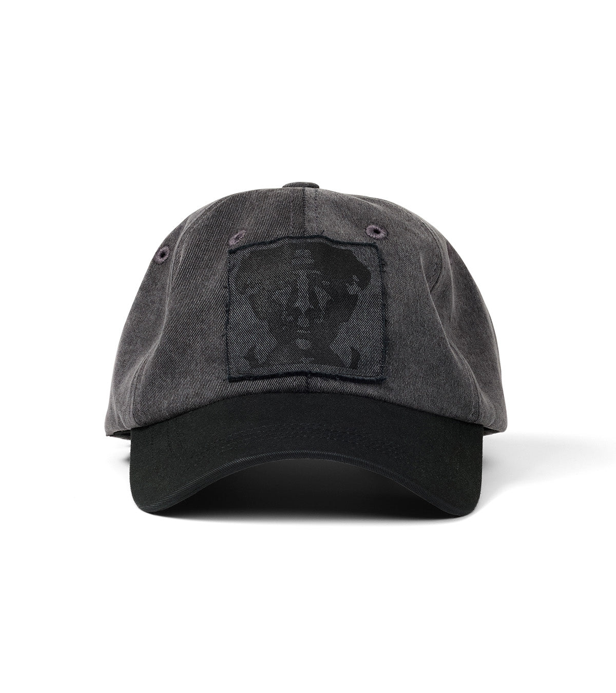 A washed black cotton baseball cap with a tonal black embroidered patch on the front, photographed against a solid white background.